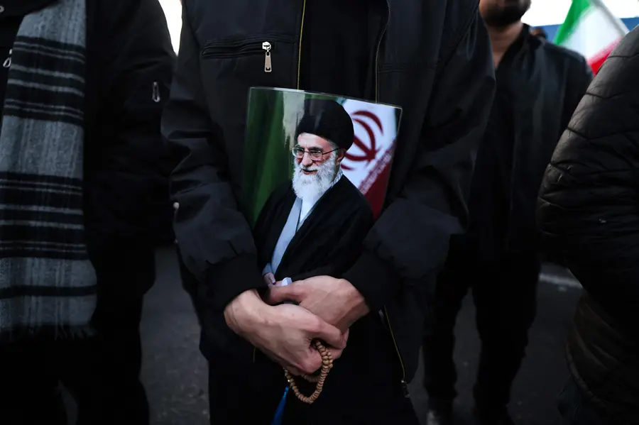 A man holds a poster of Iran’s supreme leader Ayatollah Ali Khamenei, who was killed in joint US and Israeli strikes