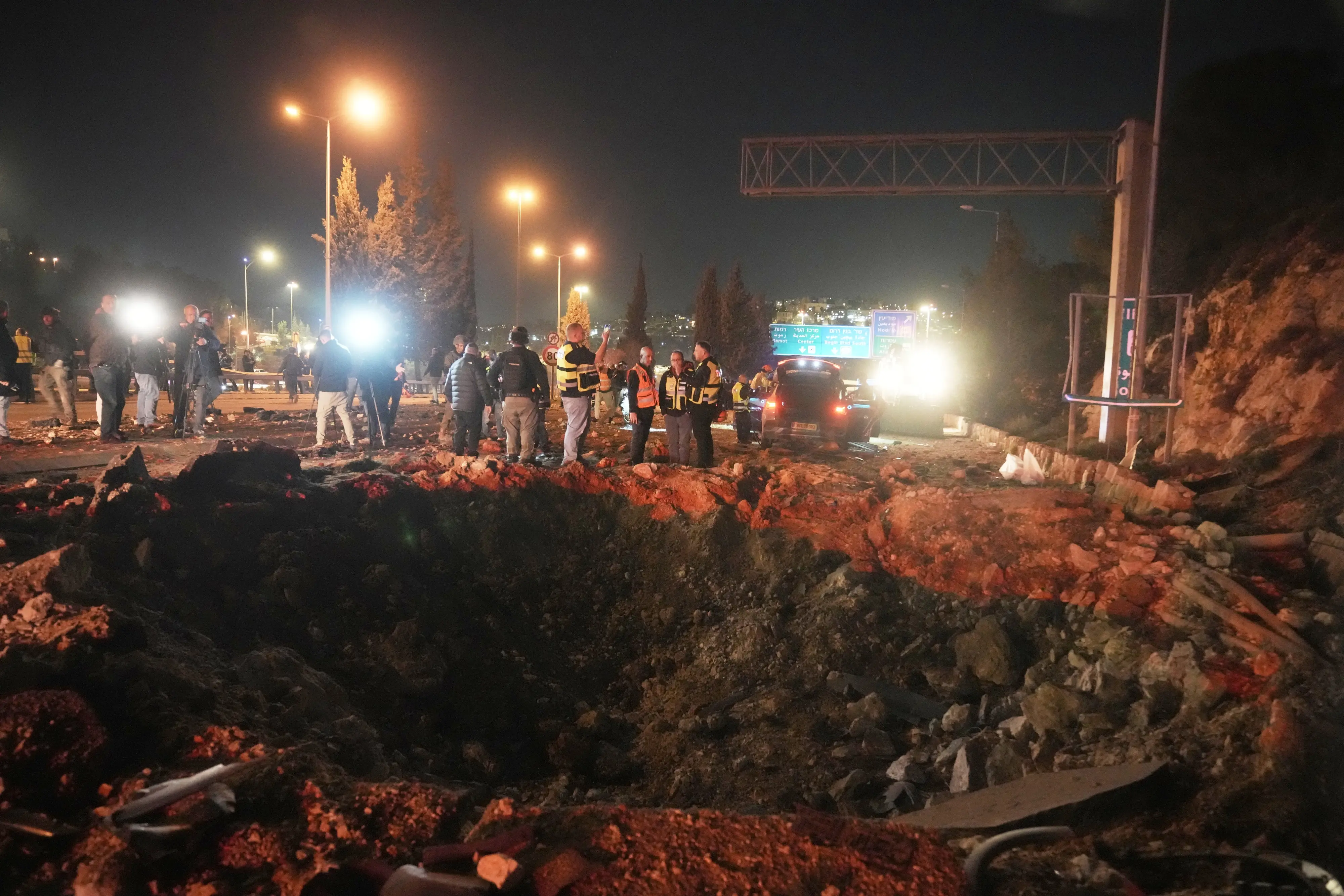 Israeli security forces inspect a damaged road after a missile launched from Iran struck Jerusalem | Photo: AP