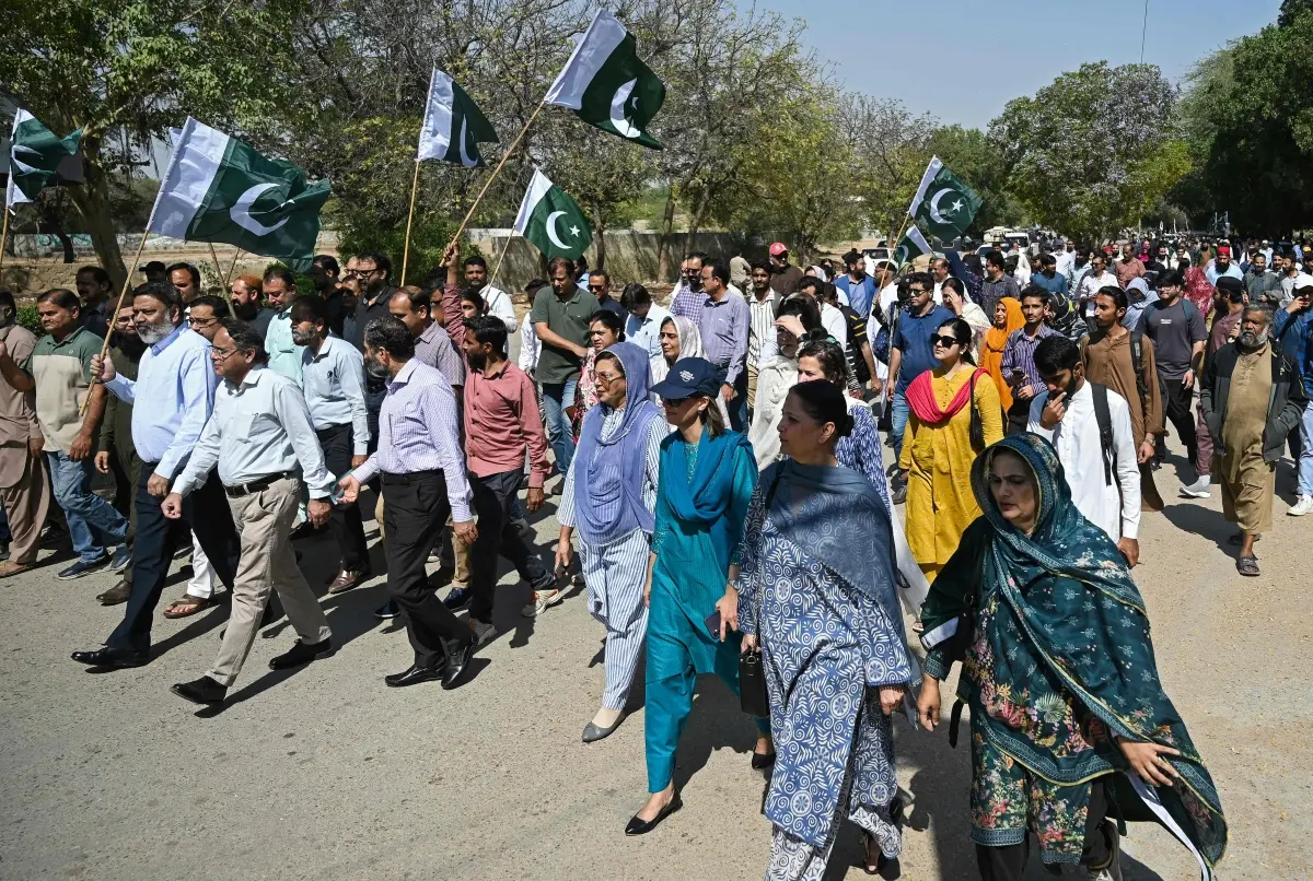 Karachi University teachers and students wave Pakistan's national flag during an anti-Afghan protest amid Pakistan-Afghanistan cross-border conflict in Karachi on March 3, 2026