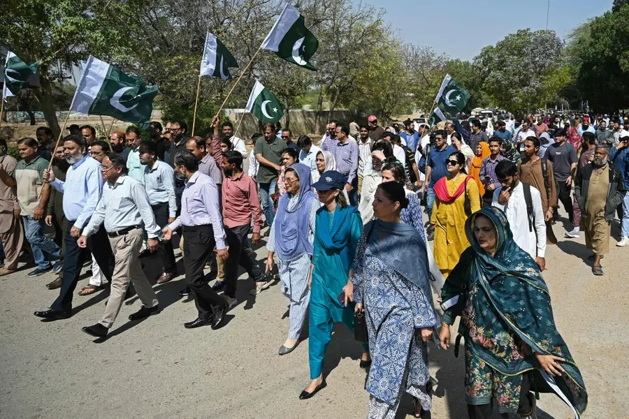 Karachi University teachers and students wave Pakistan's national flag during an anti-Afghan protest amid Pakistan-Afghanistan cross-border conflict in Karachi on March 3, 2026