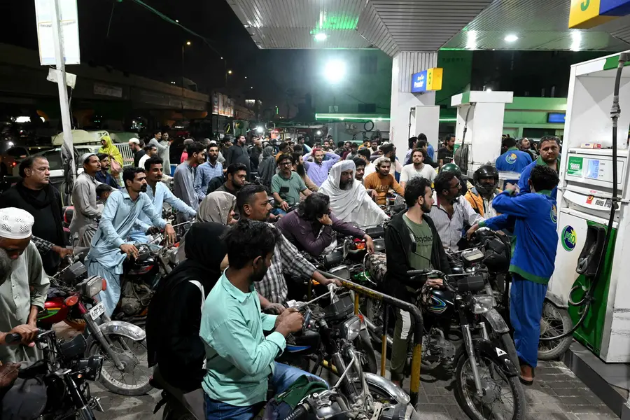 People queue at a gas station amid spikes in petrol prices in Karachi