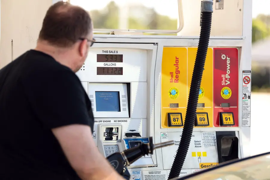 A man pumps gasoline into his vehicle at a gas station in Los Angeles, California