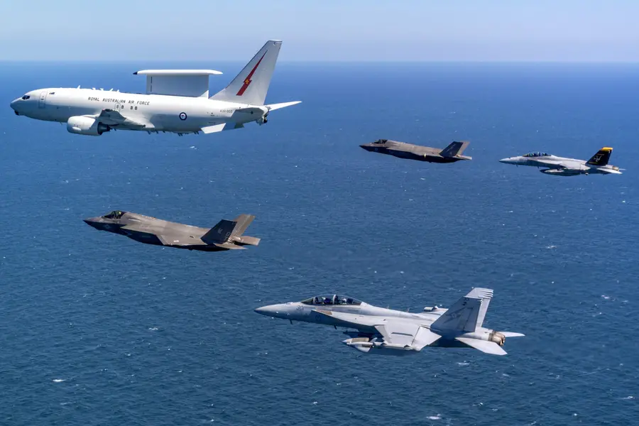 Royal Australian Air Force (RAAF) E-7A Wedgetail airborne early warning and control aircraft (top L) in formation flight with a pair of US Marine Corps (bottom C) and Royal Air Force (top C) F-35B Lightning IIs, an RAAF F/A-18F Super Hornet (top R) and RAAF EA-18G Growler electronic warfare aircraft (bottom R), over airspace in the Northern Territory of Australia during Exercise Talisman Sabre 2025