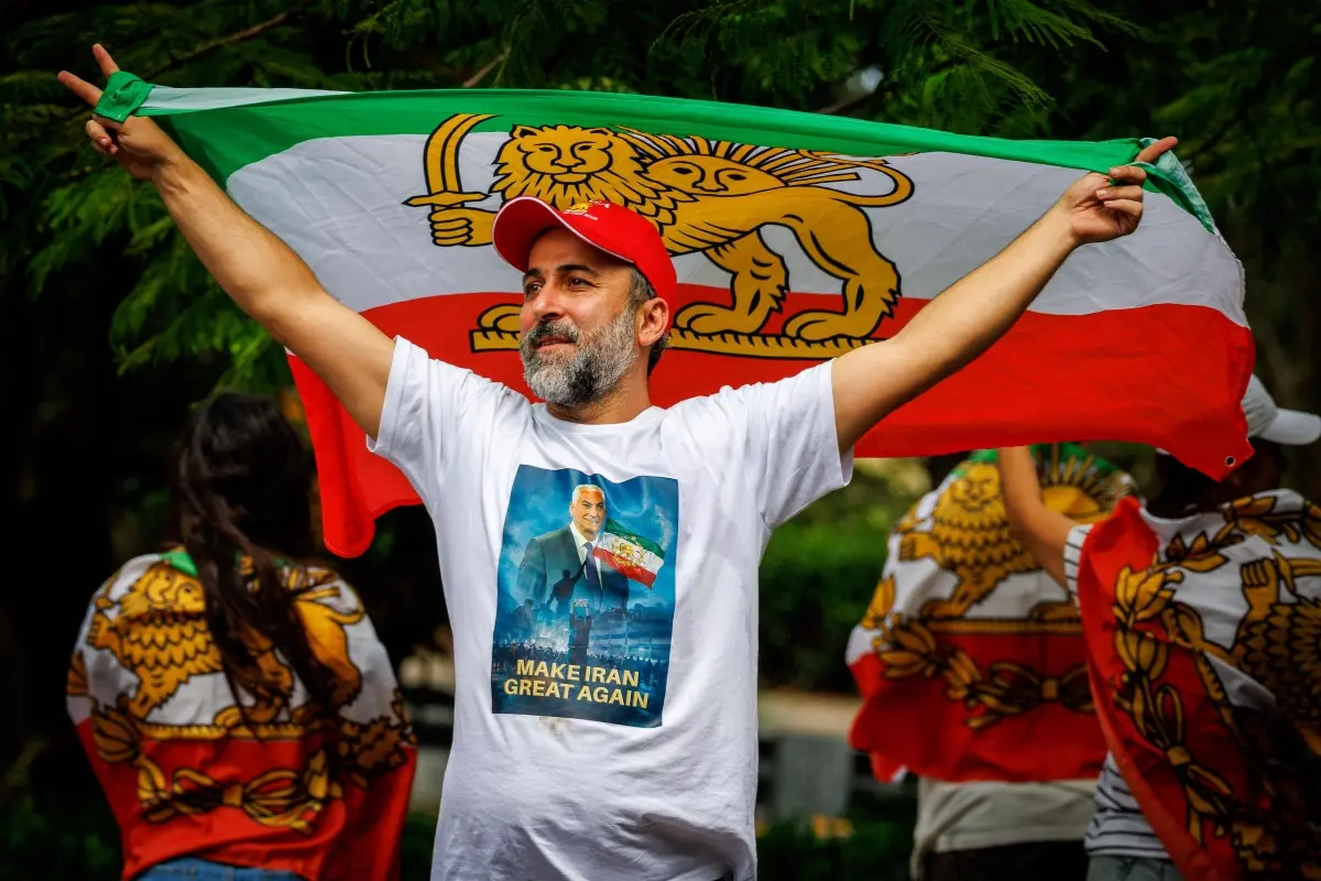 A member of the Iranian community in Australia stands with a pre-revolution Iranian flag.| Photo: AFP.