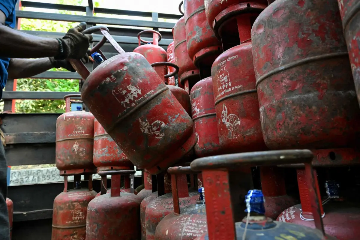 A delivery staff unloads liquefied petroleum gas (LPG) cylinders from a truck at a distribution point in Mumbai.| Photo: AFP