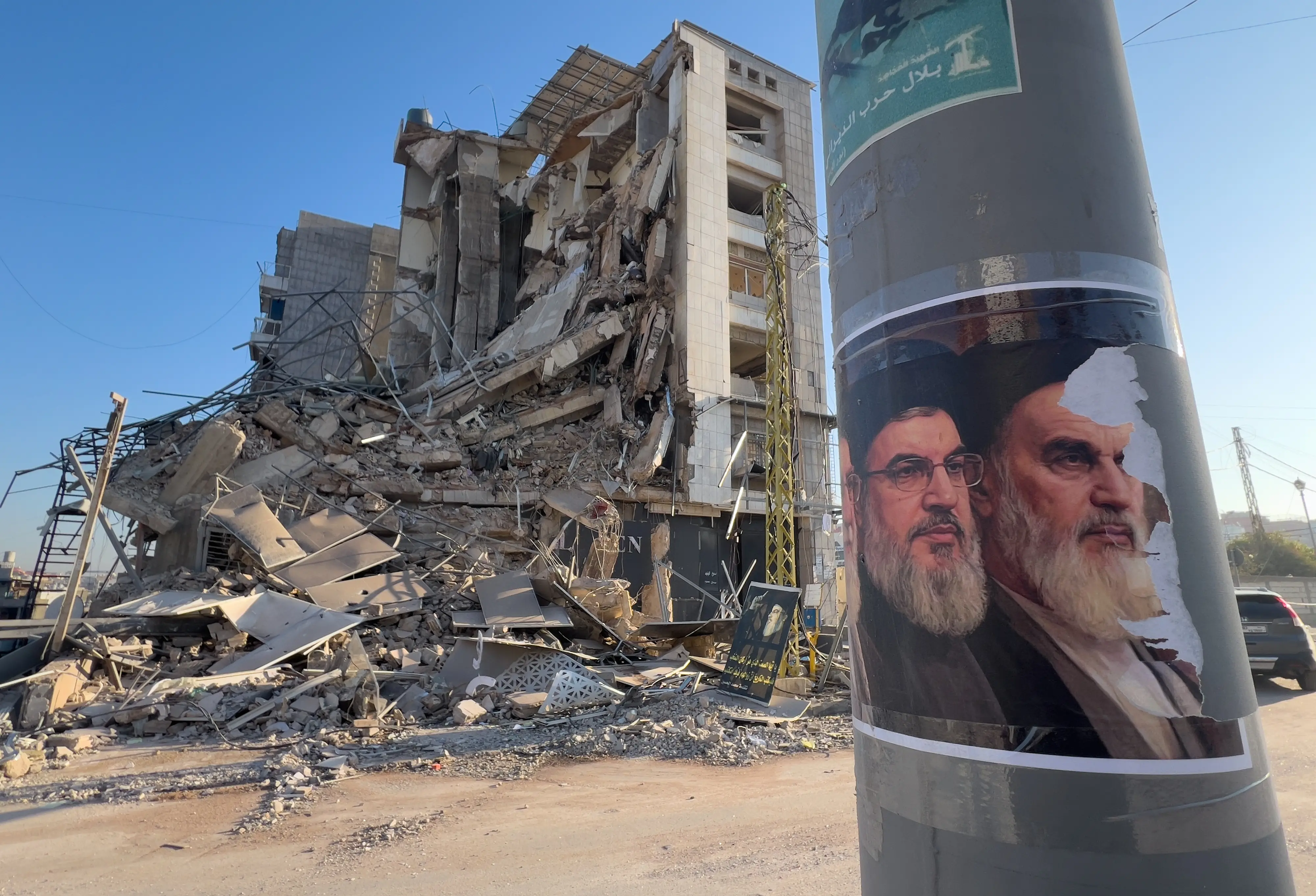 Portraits of late Hezbollah leader Sayyed Hassan Nasrallah and the late Iranian revolutionary founder Ayatollah Khomeini, are seen in front of a destroyed building in Beirut | AP