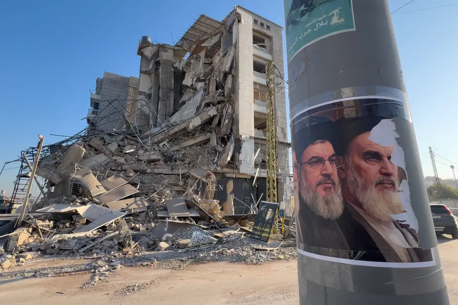Portraits of late Hezbollah leader Sayyed Hassan Nasrallah and the late Iranian revolutionary founder Ayatollah Khomeini, are seen in front of a destroyed building in Beirut