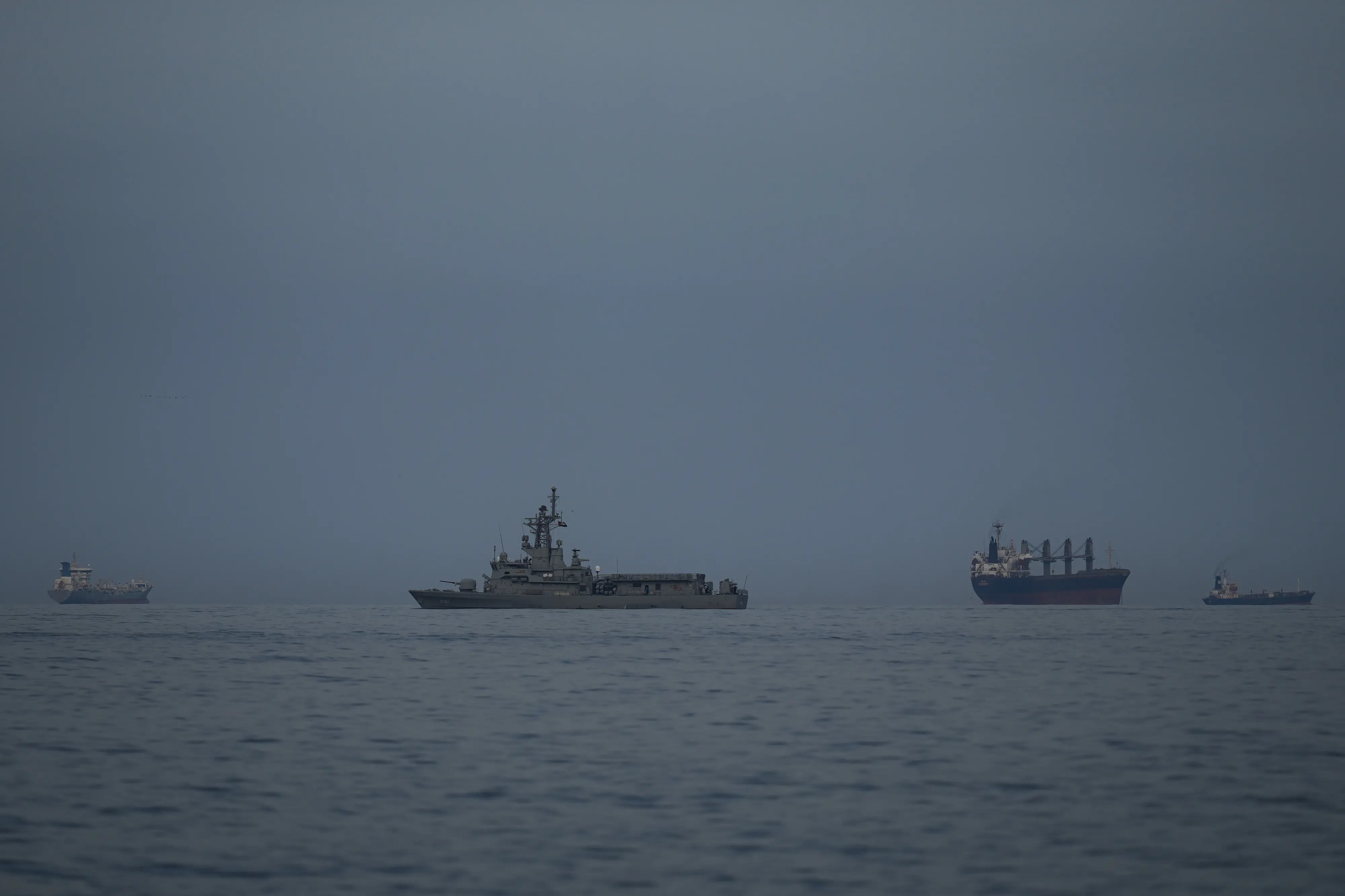 A UAE navy vessel patrols next to cargo ships and oil tankers in the Strait of Hormuz as seen from Khor Fakkan, United Arab Emirates | Photo: AP