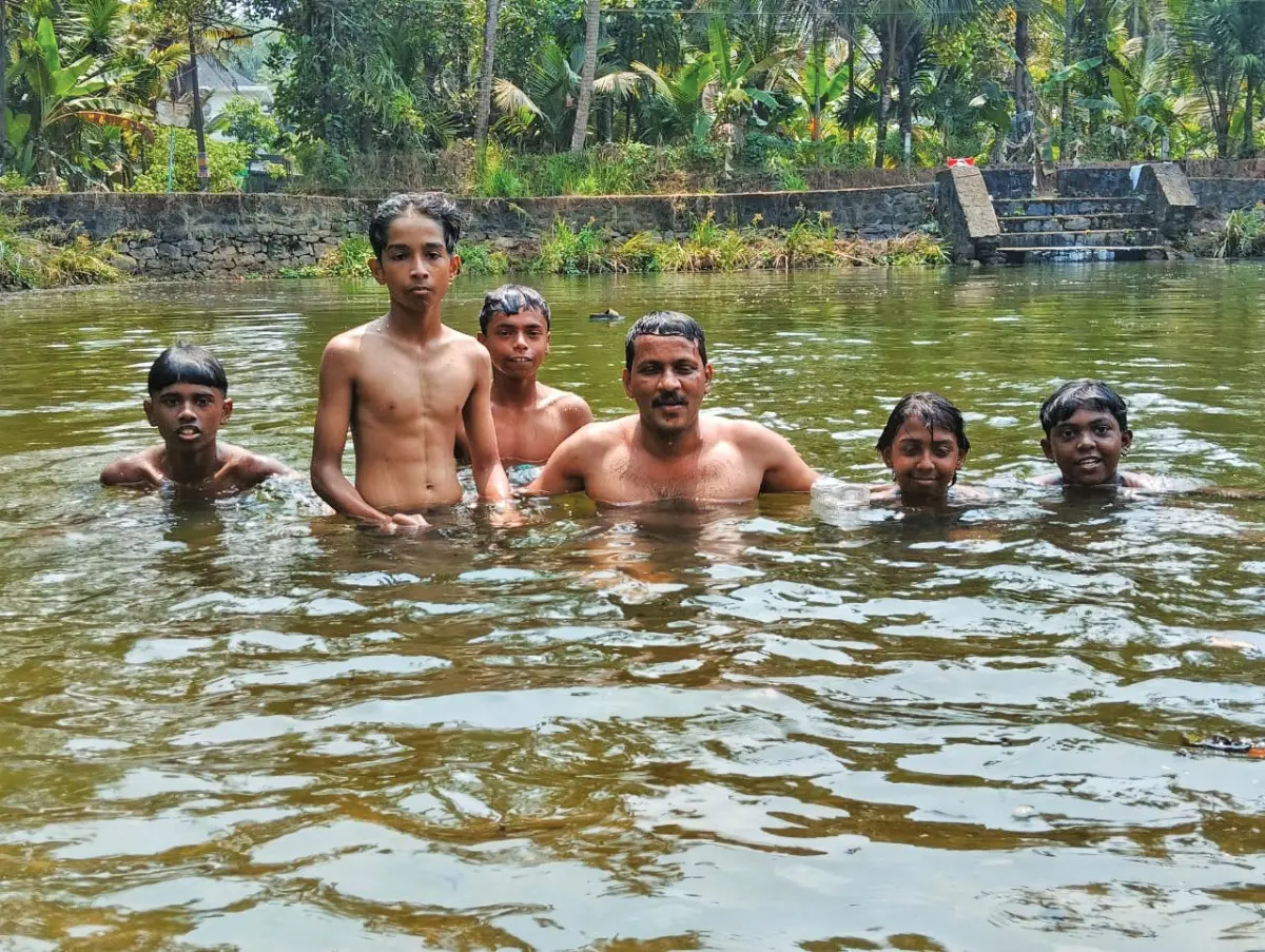 മാലിന്യം നീക്കിയശേഷം കുട്ടികൾക്കൊപ്പം കുളത്തിൽ നീന്തിത്തുടിക്കുന്ന എ.എസ്.ഐ. അമൽ