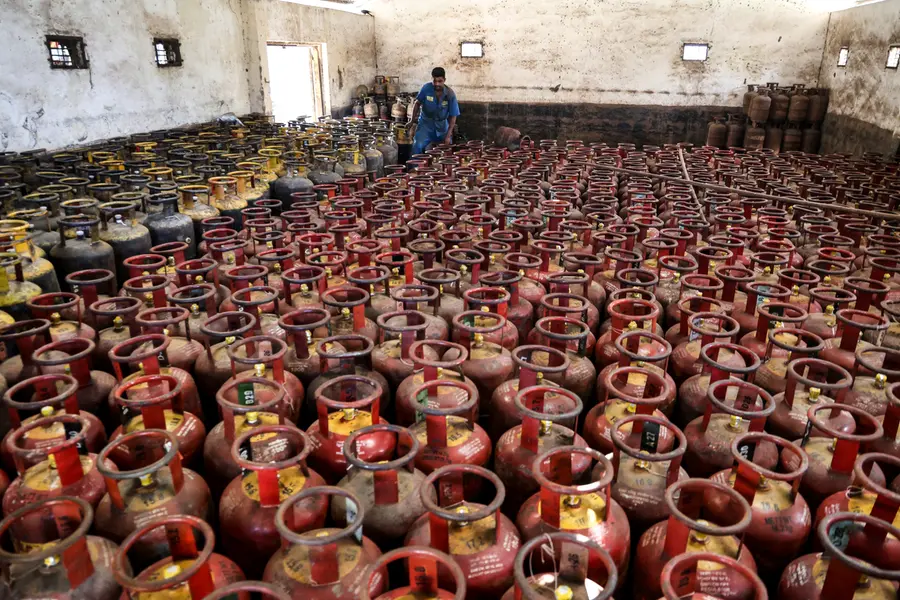 A man arranges LPG cylinders inside a godown amid supply crisis in the country