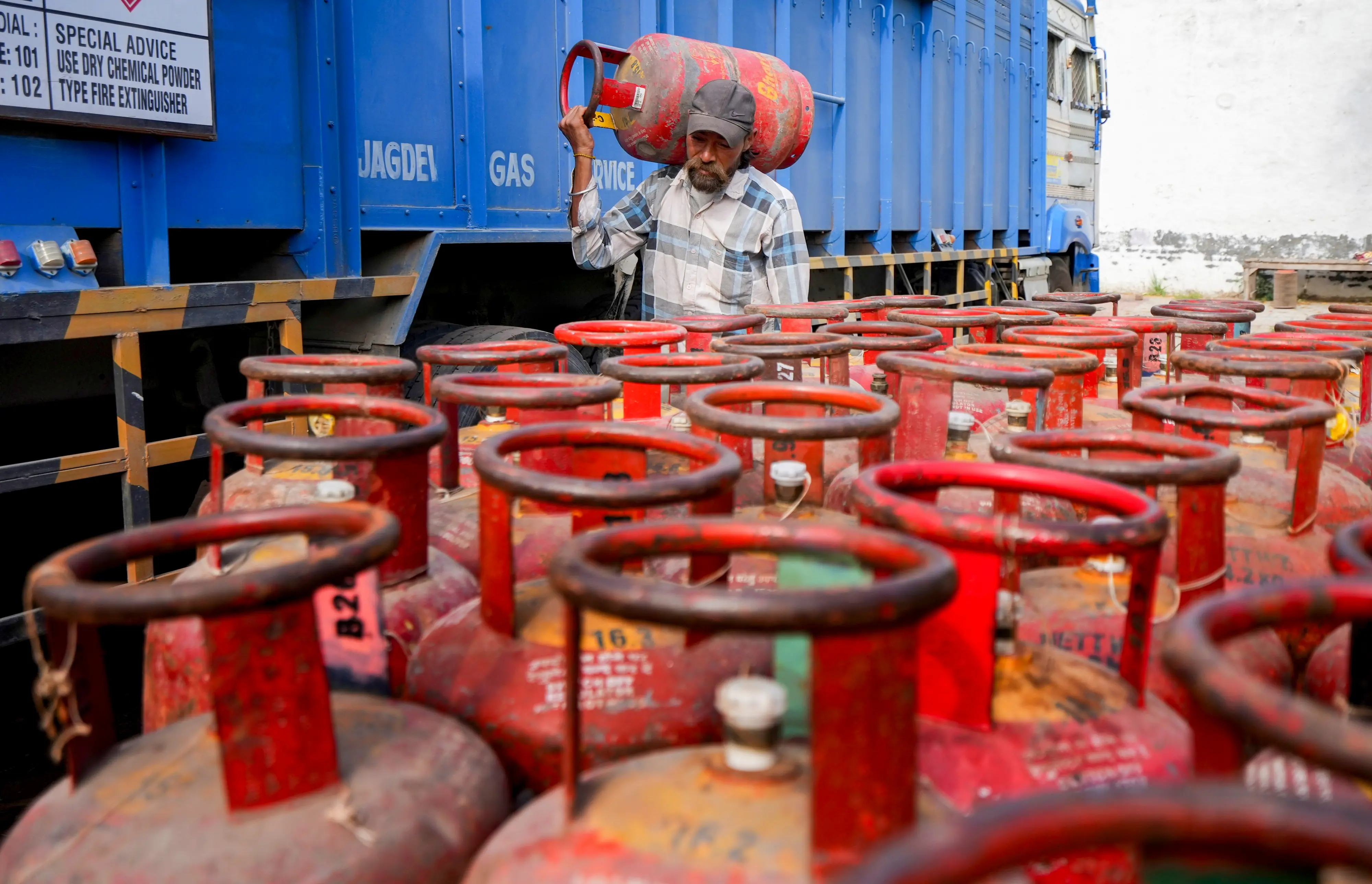 A worker carries a LPG cylinder at a distribution centre amid fuel shortages in the wake of the ongoing West Asia conflict, in Amritsar | PTI