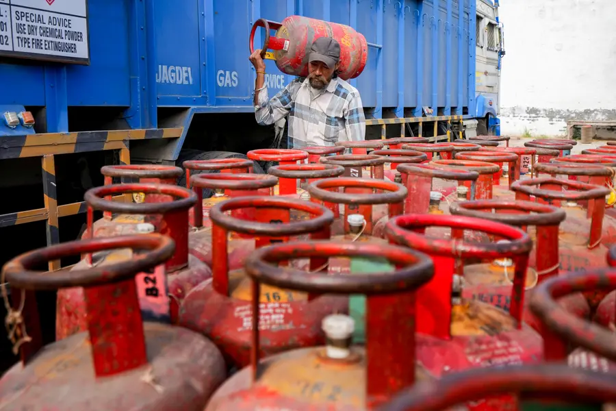 A worker carries a LPG cylinder at a distribution centre amid fuel shortages in the wake of the ongoing West Asia conflict, in Amritsar