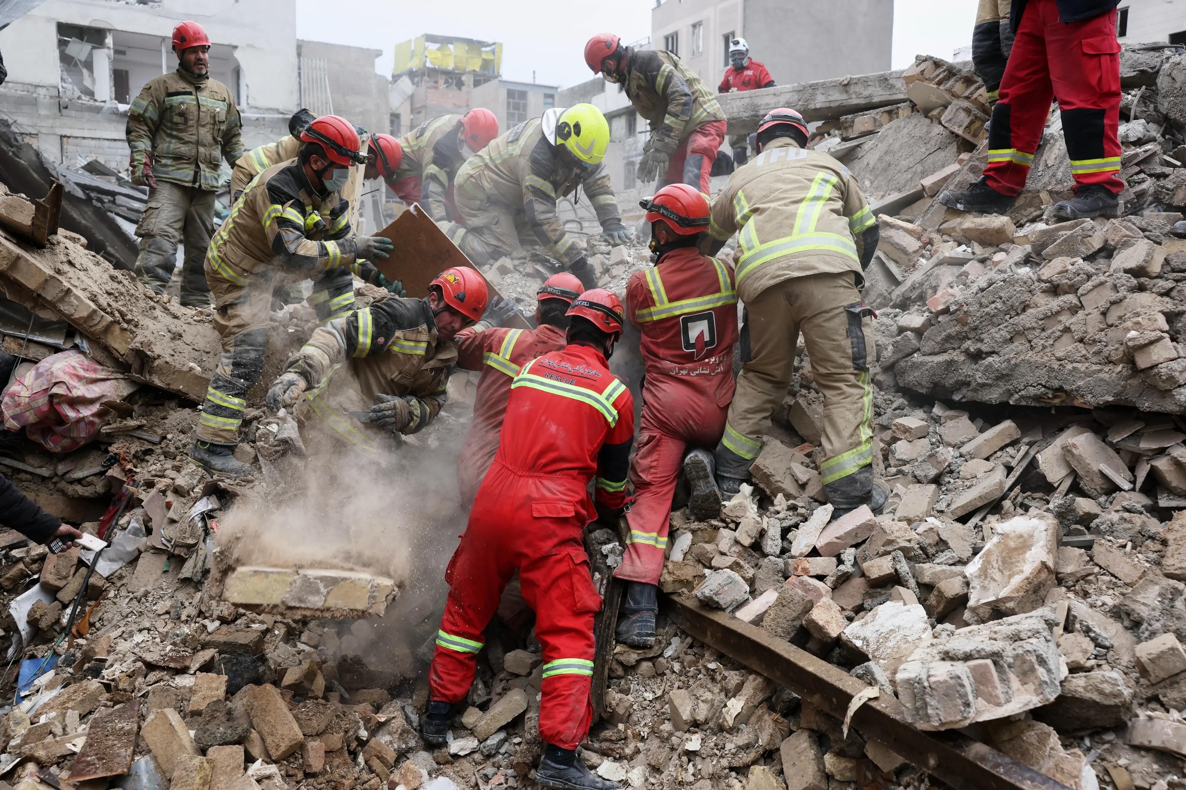 Rescue workers search for survivors in the rubble after a strike in southern Tehran | Photo: AP
