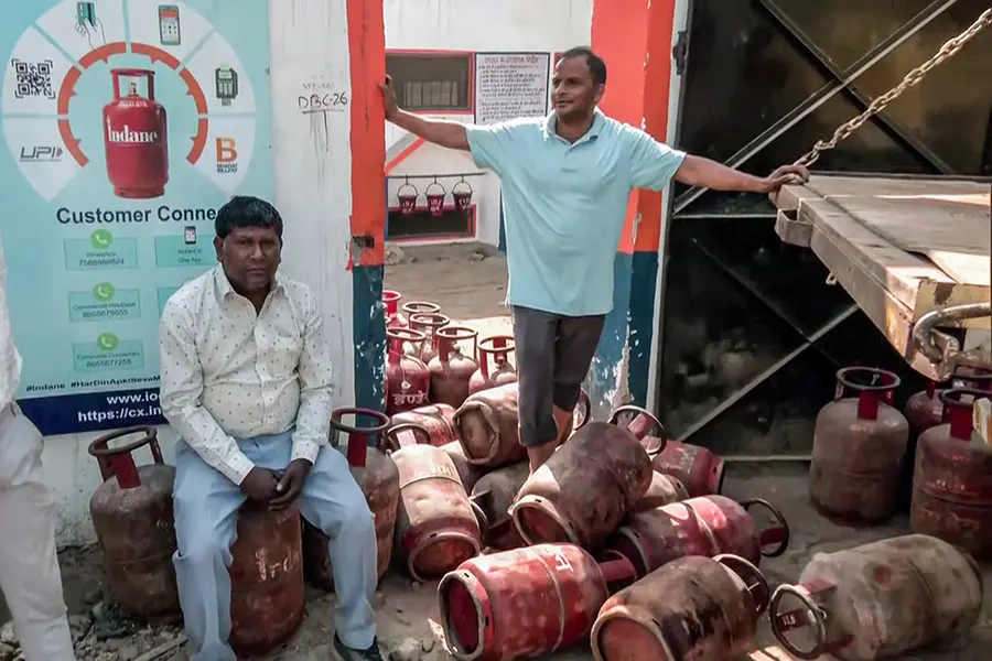 A man stands on an LPG cylinder at a gas agency amid the reports of LPG supply shortage in the country