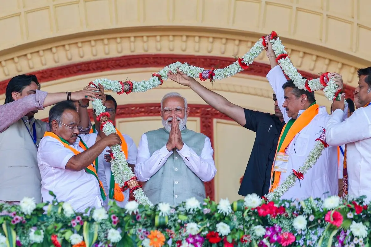 Prime Minister Narendra Modi being garlanded by West Bengal BJP President Samik Bhattacharya, LoP in the state Assembly Suvendu Adhikari during a rally, at Brigade Parade Ground in Kolkata. (PTI Photo)