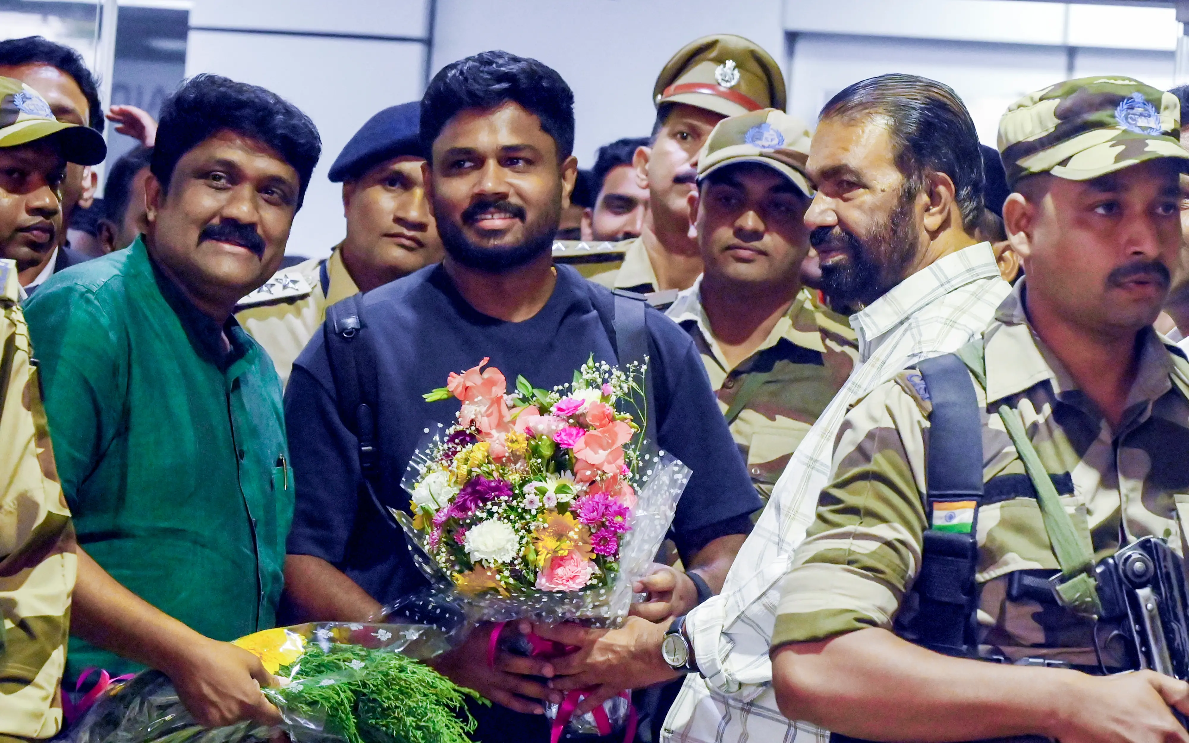 Sanju Samson is welcomed by Education Minister V Sivankutty and MP AA Rahim, left, on his arrival at Thiruvananthapuram International Airport | File photo: PTI