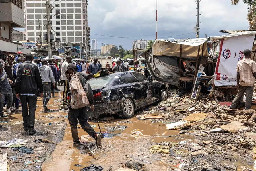 People walk around damaged property looking for salvageable items in downtown Nairobi following heavy rainfall that resulted in severe flooding.