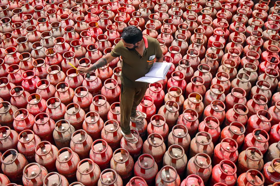 Worker sorts out domestic gas cylinders at an Indian Oil godown on the outskirts of Amritsar