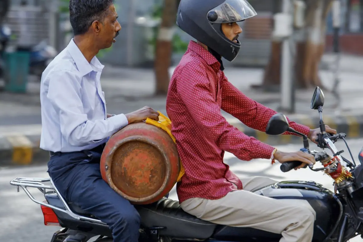 A man carries his empty LPG cylinder on bike as he arrives at the LPG depot, amid reports of a nationwide shortage, in Ahmedabad on Wednesday (Photo: ANI)