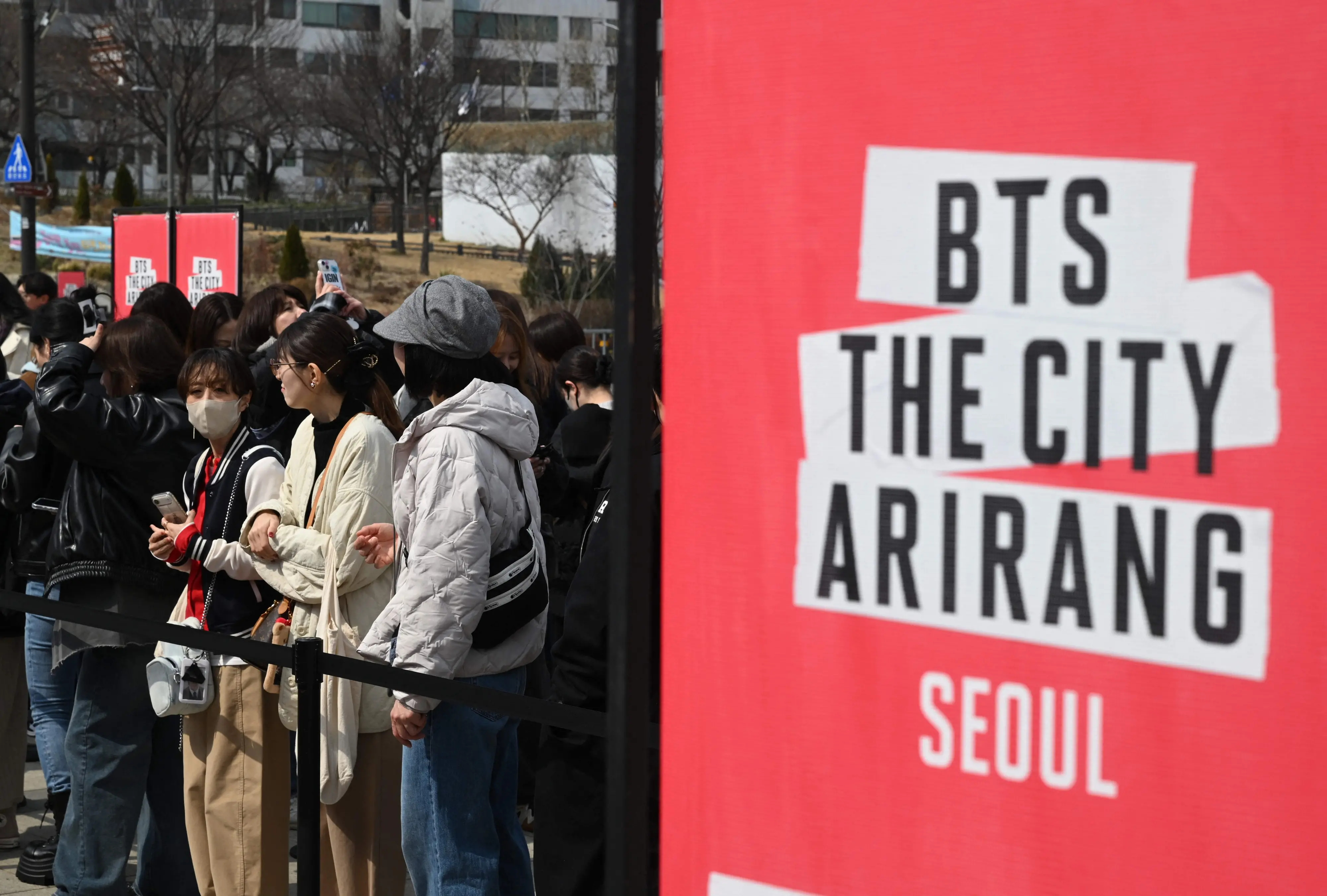 BTS fans wait in a line to enter a fan zone promoting the new album of K-pop boy band BTS at a riverside park in Seoul on March 20, 2026 | AFP