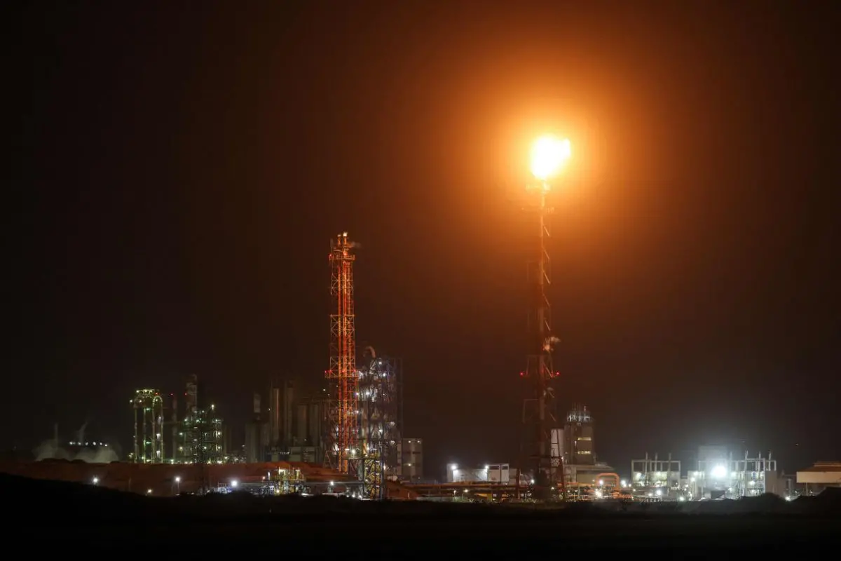 Trails and lights from missile defence interceptors are seen in the sky, as excess gas is burned at the oil refinery in Israel's northern city of Haifa late on March 19, 2026. (Photo by Odd ANDERSEN / AFP)