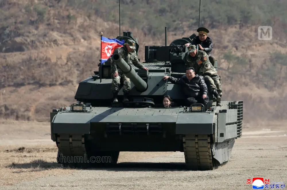 This picture taken on March 19, 2026 and released by North Korea's official Korean Central News Agency (KCNA) via KNS on March 20, 2026 shows North Korean leader Kim Jong Un and his daughter Kim Ju Ae boarding a tank during their visit to the Pyongyang Training Base No. 60 under the Capital City Defence Corps of the North Korean's Army | AFP