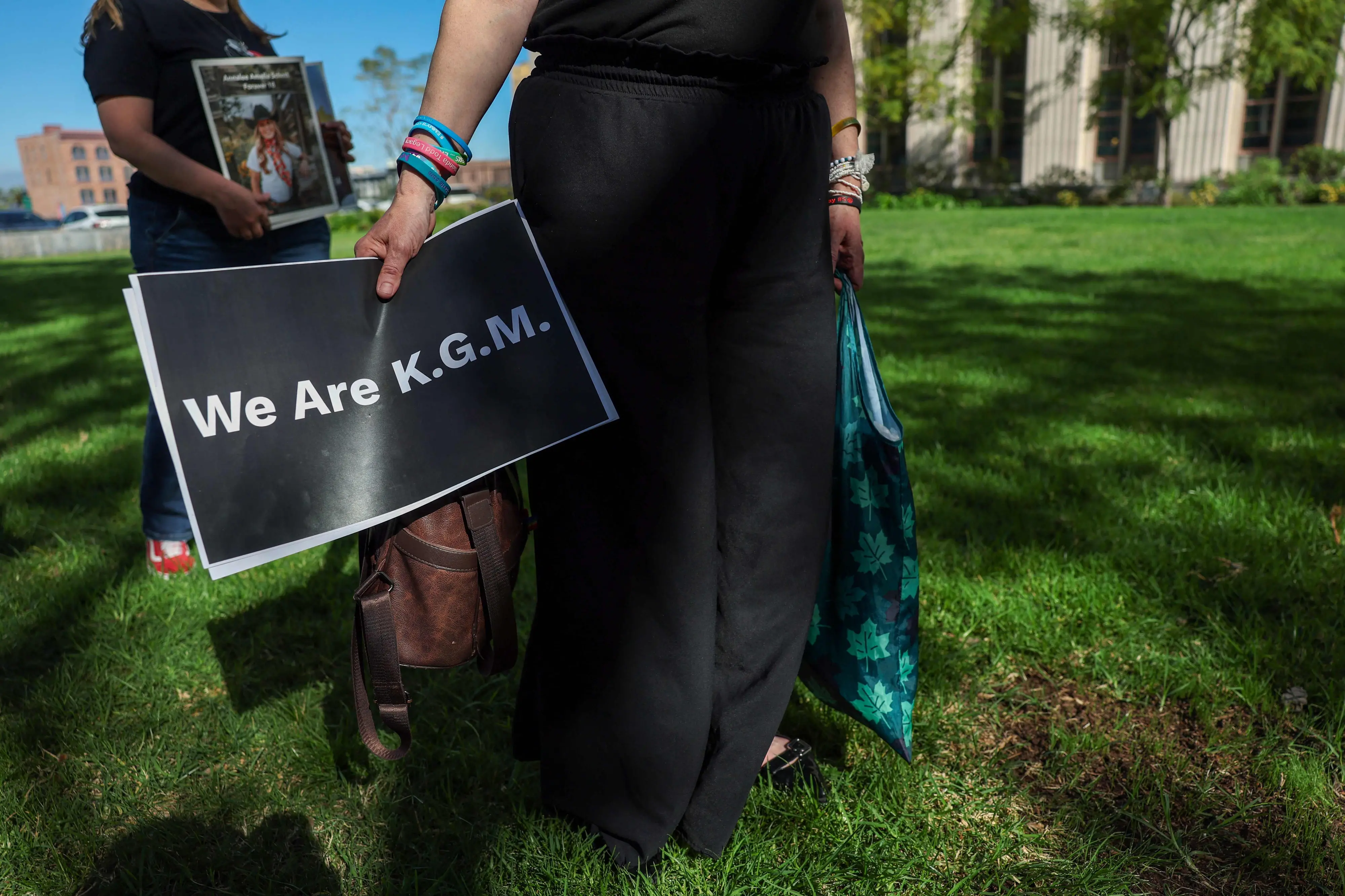 A person holds a sign that reference a plaintiff, only identified by her initials, as people wait for a verdict in the social media trial tasked to determine whether social media giants deliberately designed their platforms to be addictive to children, in Los Angeles | Photo: AFP