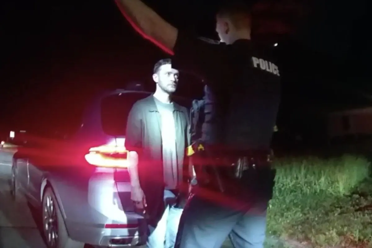 Justin Timberlake stands under police lights during a roadside sobriety test after being pulled over in New York's Hamptons in June 2024. (Screengrab: AP video)