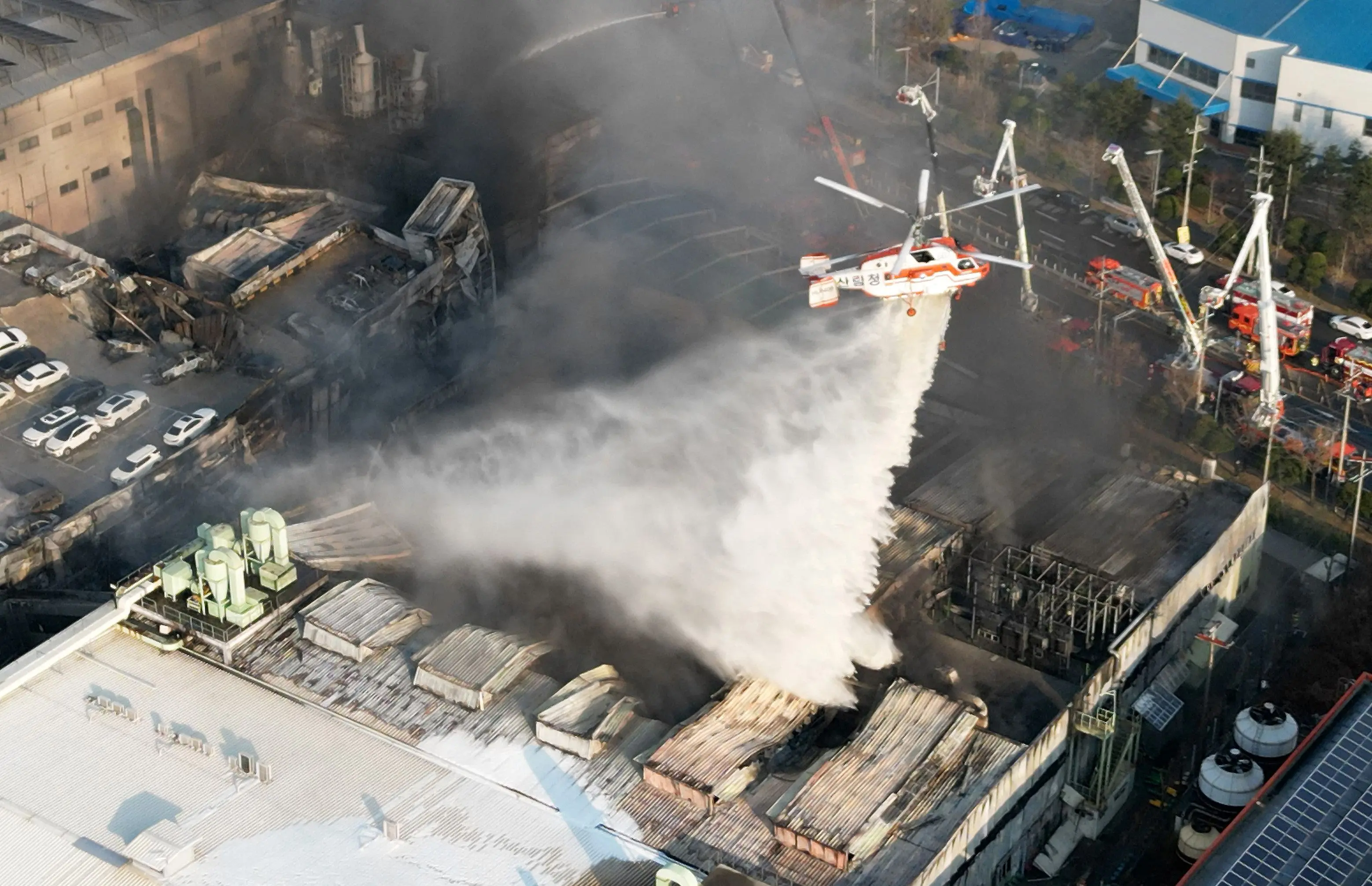A firefighting helicopter drops water to extinguish a fire at a car parts plant in South Korea's Daejeon | Photo: AFP
