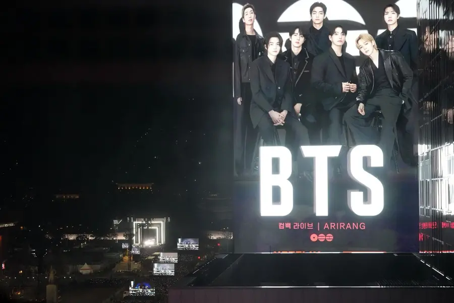 K-pop band BTS perform on the stage, left, during the comeback concert at Gwanghwamun Square in Seoul, South Korea