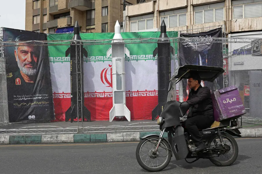 A motorist rides past the dummy models of Iranian missiles installed along the roadside at Valiasr Square in Tehran
