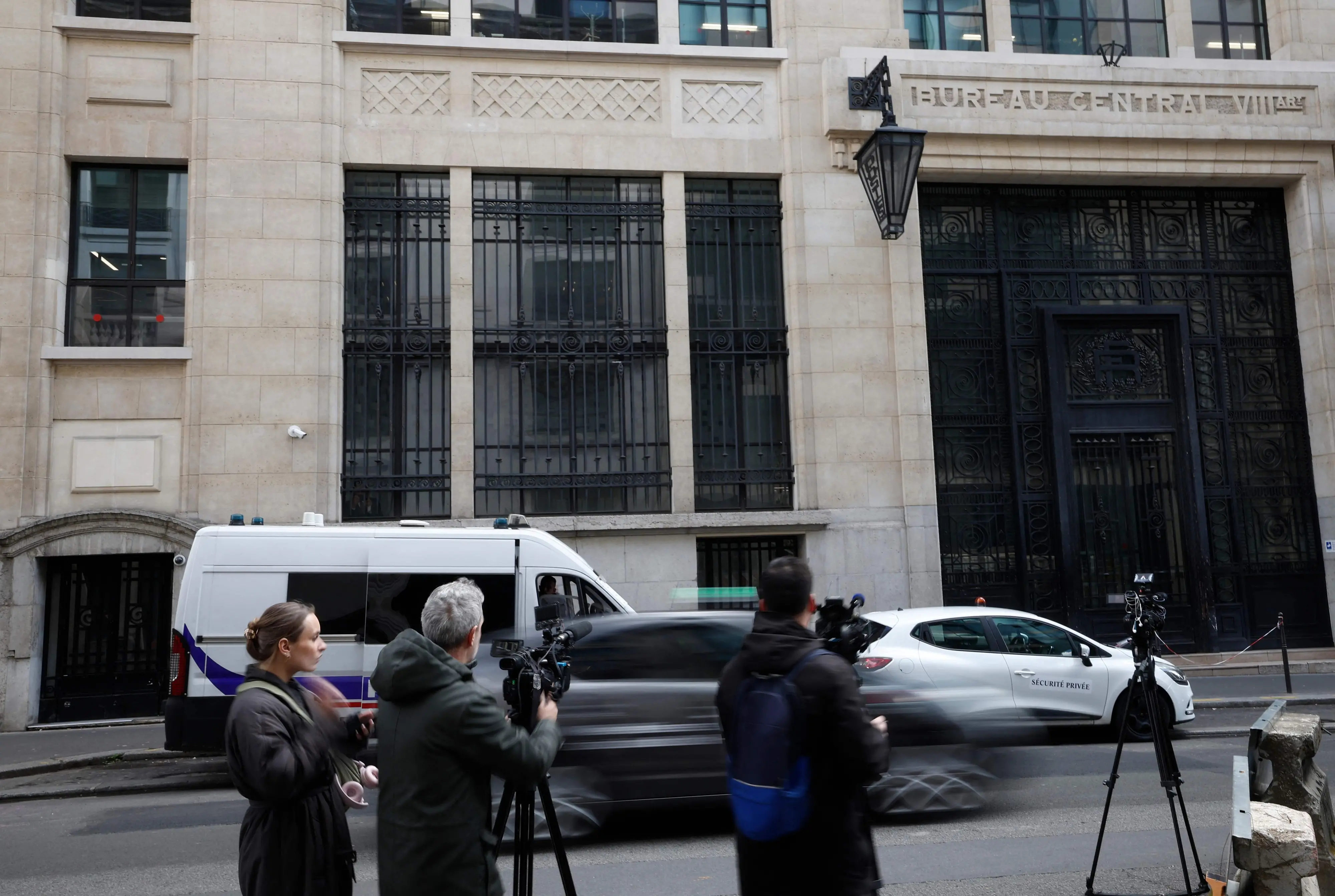 Media representatives gather outside The Bank of America building in the 8th arrondissement of Paris on March 28, 2026, following an apparent bomb attack attempt.| AFP