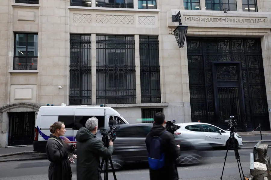 Media representatives gather outside The Bank of America building in the 8th arrondissement of Paris