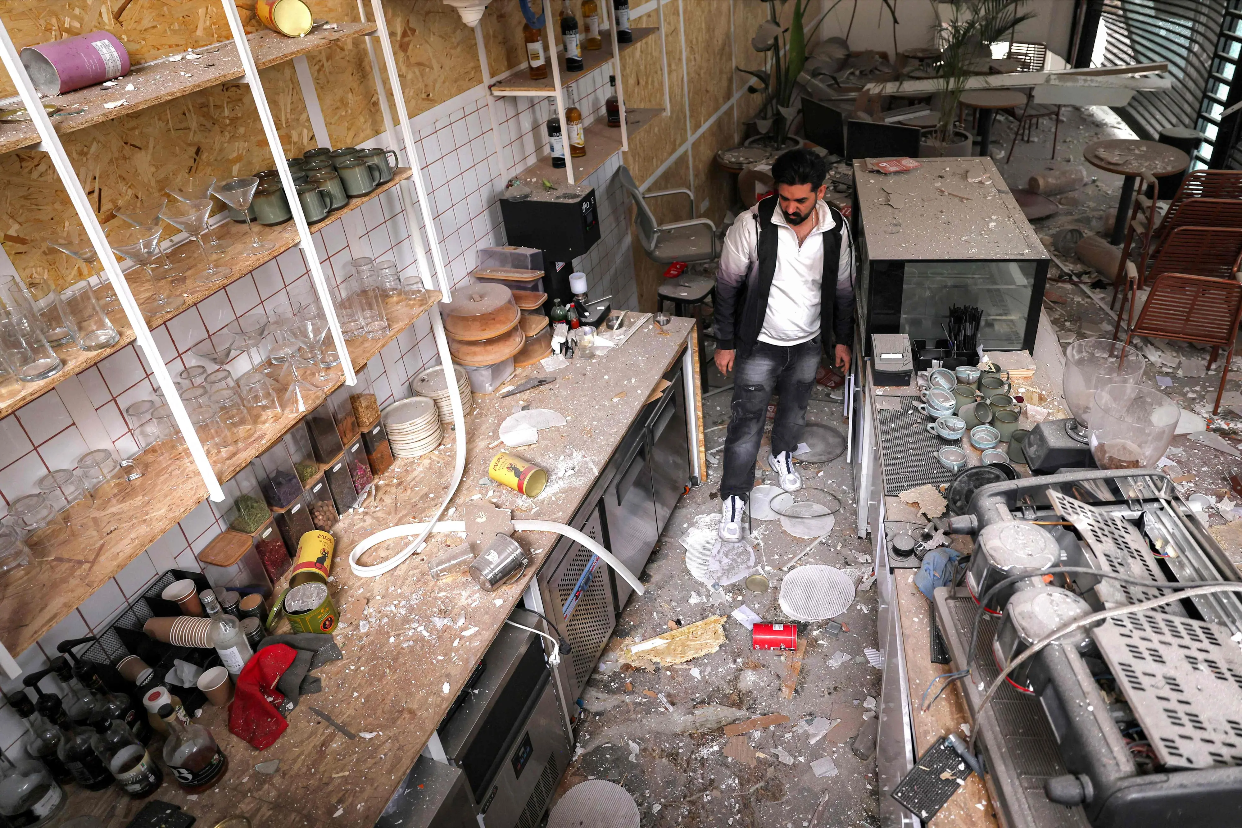 Cafe staff inspect the destruction at the premises following a missile strike on their building earlier in the day in Tehran | AFP
