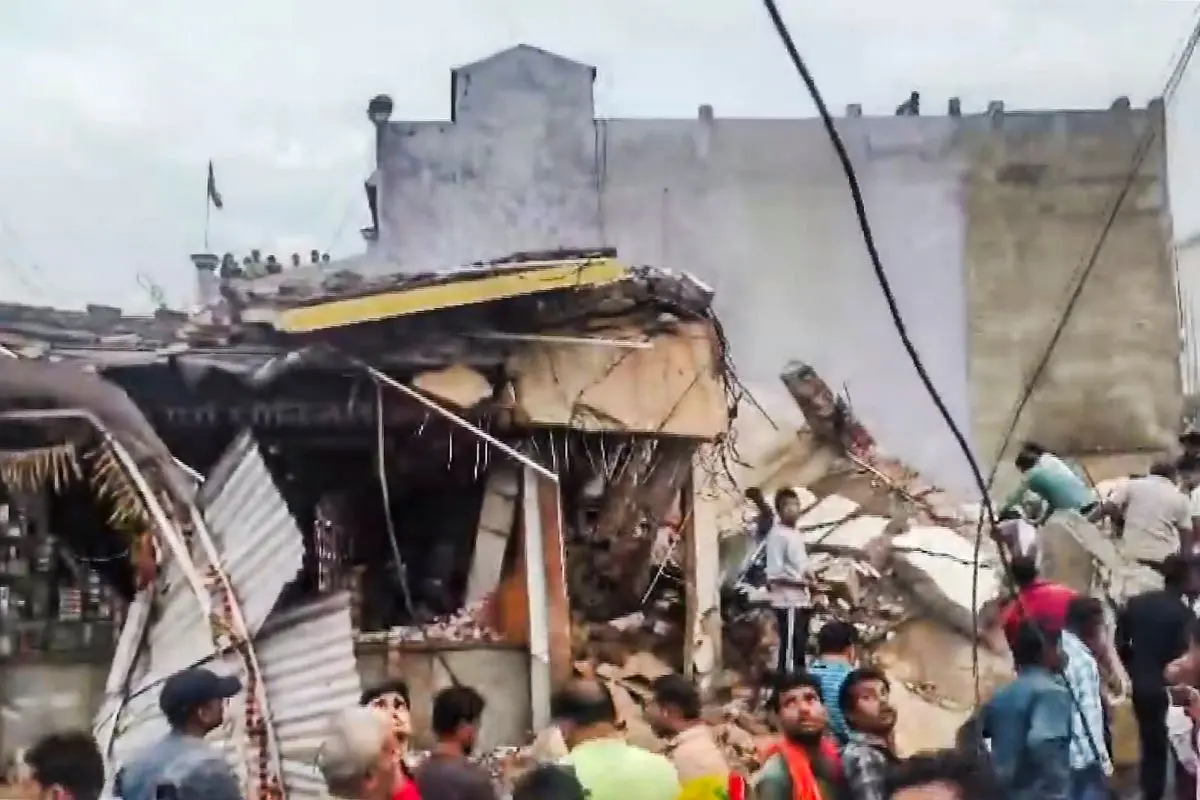 People gather after a four-storey building collapsed, trapping at least six persons in the debris, at Kotma town, in Anuppur district, Madhya Pradesh, Saturday, April 4, 2026. (PTI Photo)