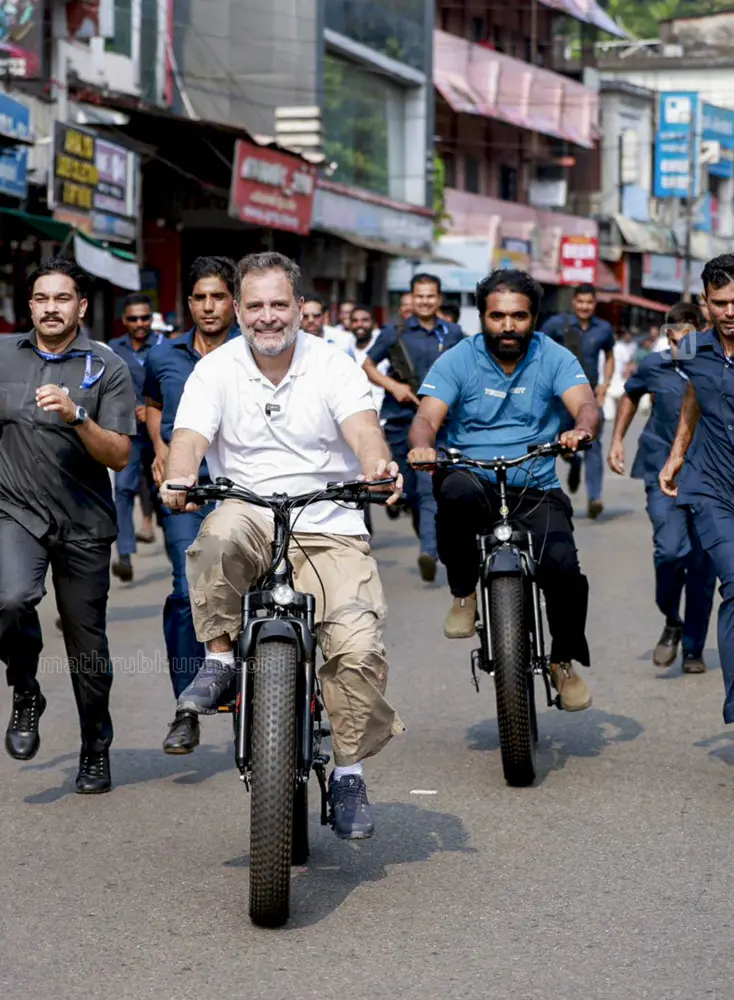 Congress leader Rahul Gandhi rides a bicycle as he campaigns in support of UDF candidate Chandy Oommen, cycling behind, from Puthuppally constituency | PTI