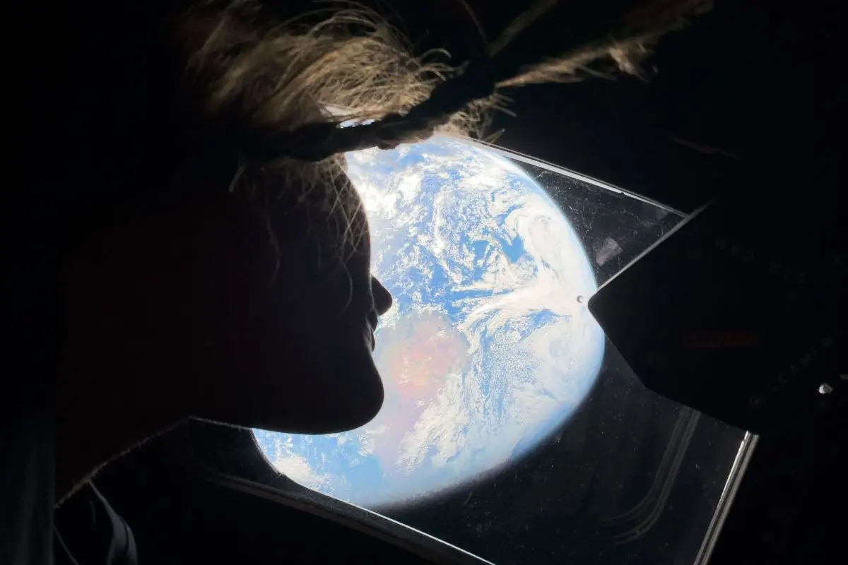 This image provided by NASA, astronaut and Artemis II mission specialist Christina Koch peers out of one of the Orion spacecraft's main cabin windows, looking back at Earth, as the crew travels towards the Moon on Thursday, April 2, 2026 (Photo: AP)