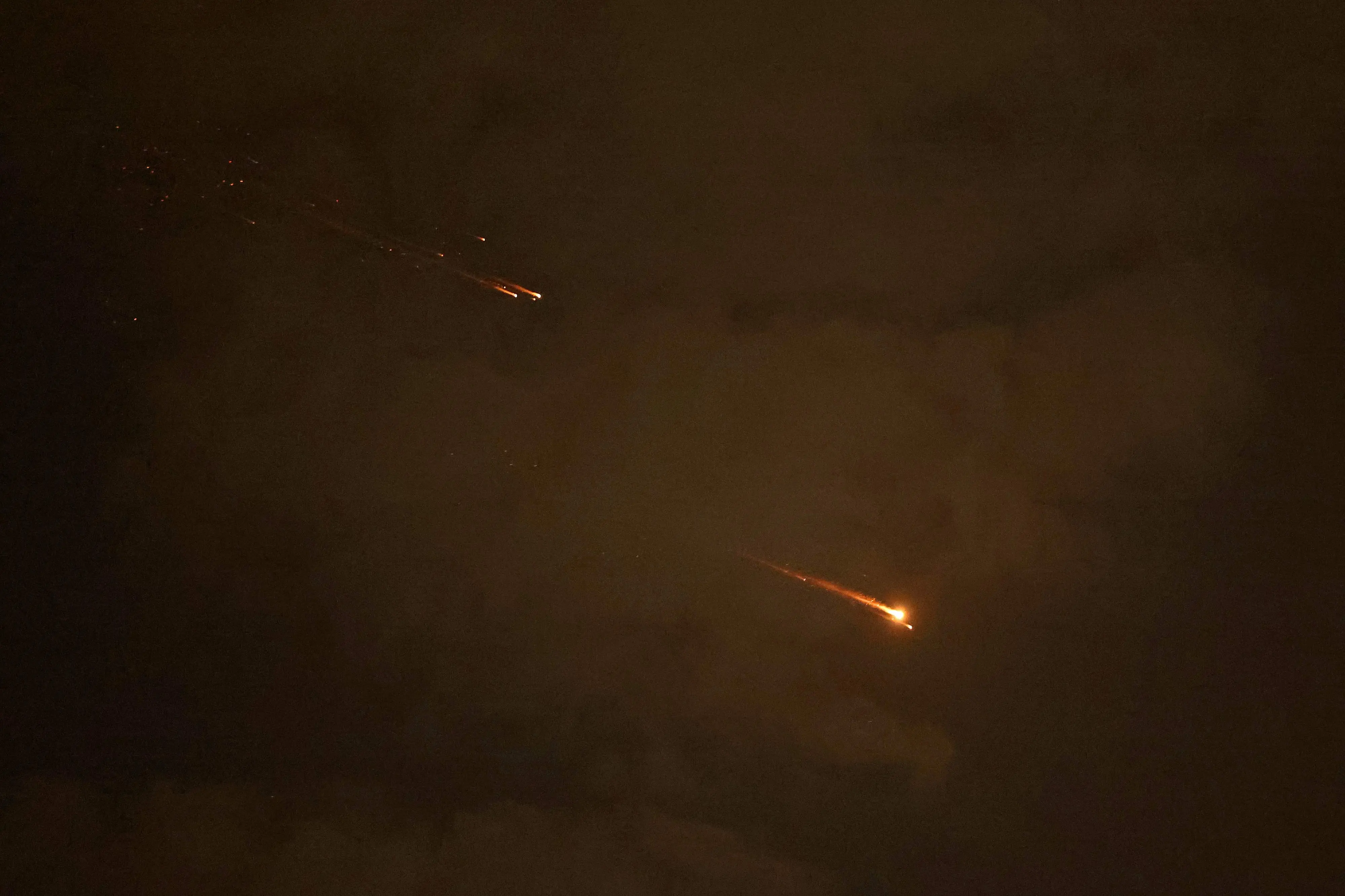 Rocket trails are seen in the sky above the Israeli coastal city of Netanya amid a fresh barrage of Iranian missile attacks | AFP