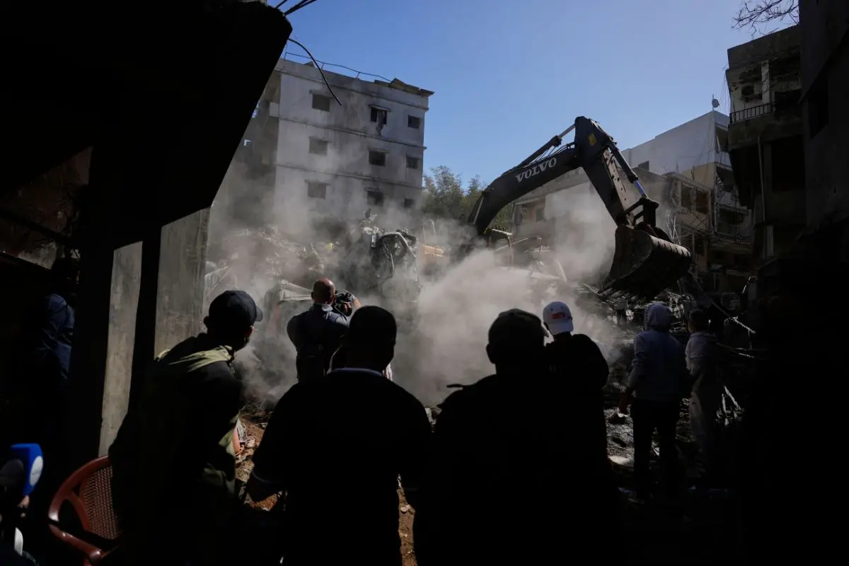 People gather as an excavator clears rubble at the site of Sunday's Israeli strike on a building in Beirut's Jnah neighborhood, Lebanon, Monday, April 6, 2026. (Photo: AP)