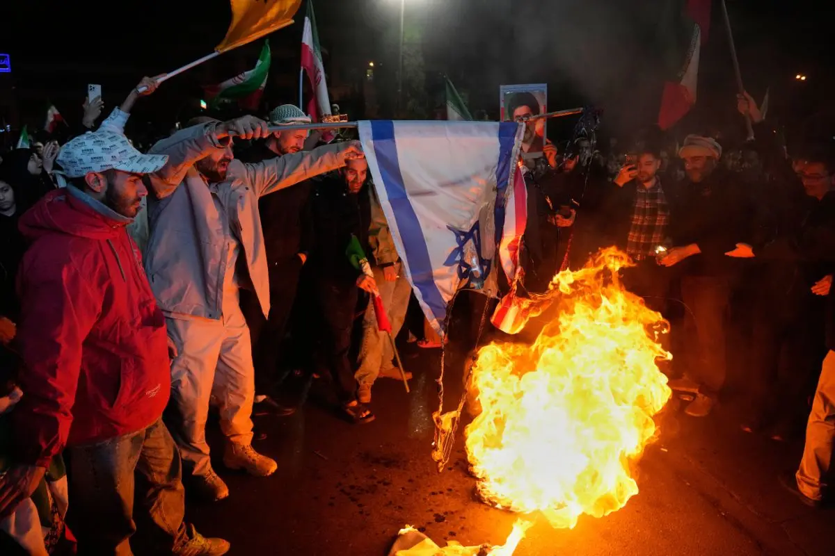 Iranian pro-government demonstrators burn the U.S. and Israeli flags during a gathering after announcement of a two-week ceasefire in the war with the United States and Israel, at the Enqelab-e-Eslami, or Islamic Revolution, Square, in Tehran, Iran, Wednesday, April 8, 2026 (Photo: AP)
