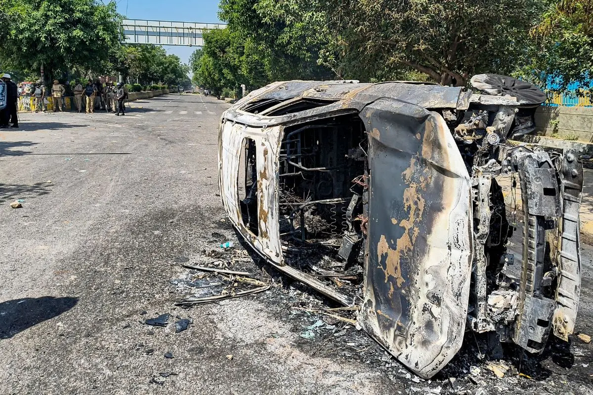 Wreckage of a car is seen after it was burnt during a protest by factory workers demanding a hike in wages, in Noida, Gautam Buddh Nagar district, Uttar Pradesh, Monday, April 13, 2026. (PTI Photo)