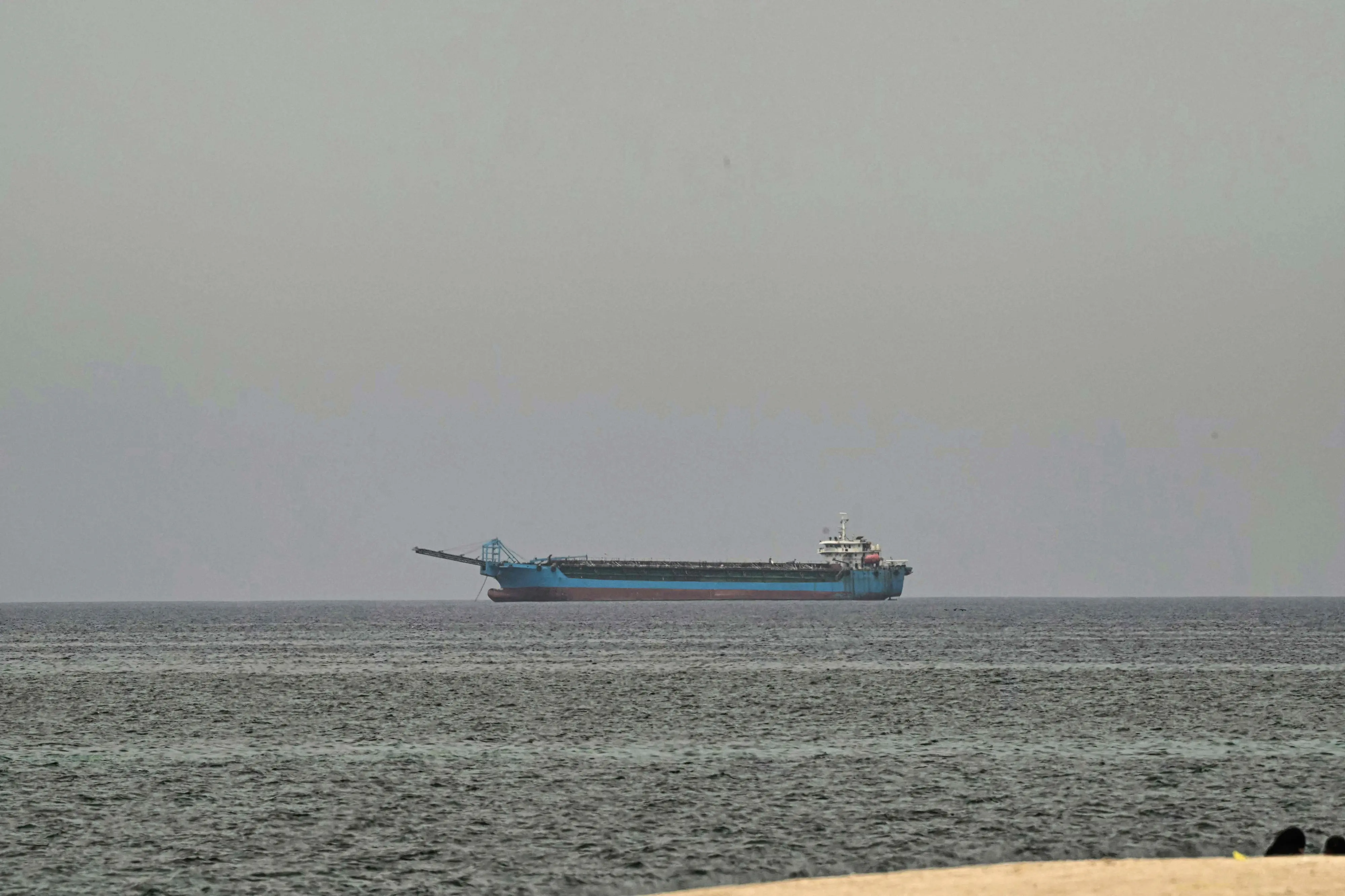 A ship is seen off the coast of Sharjah, the day after the failure of US-Iran peace talks on April 13, 2026. | AFP