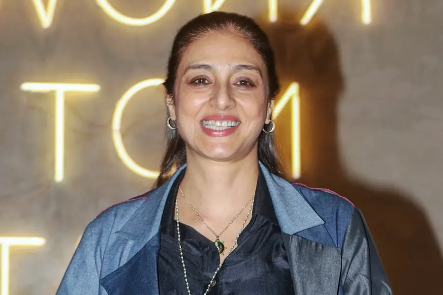 A sophisticated and elegant portrait of Bollywood actress Tabu, known for her versatile roles, dressed in a stylish outfit