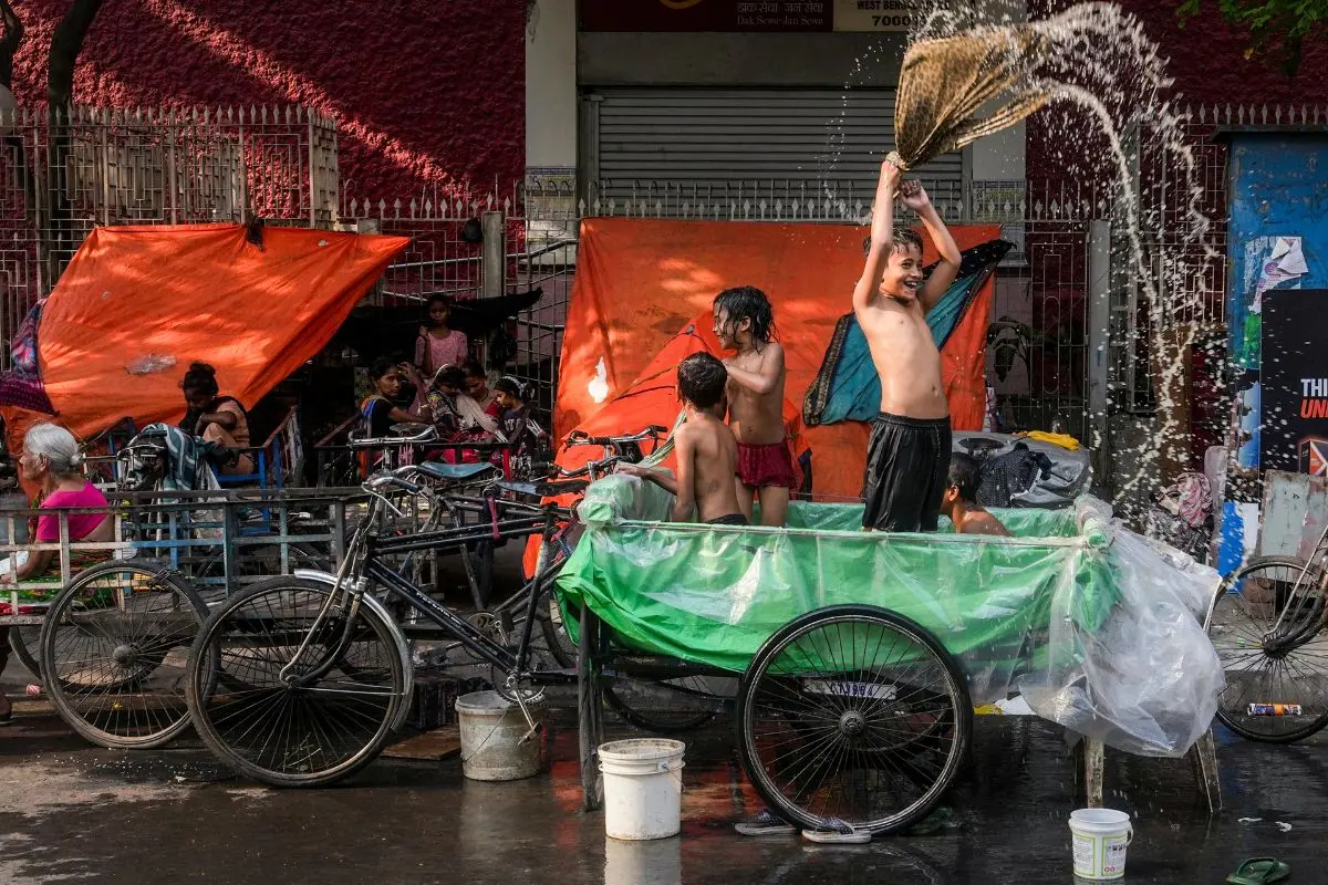 Children cool off in an improvised pool set up on a cycle rickshaw on a hot summer day, in Kolkata, Sunday, April 19, 2026. (PTI Photo/Manvender Vashist Lav)