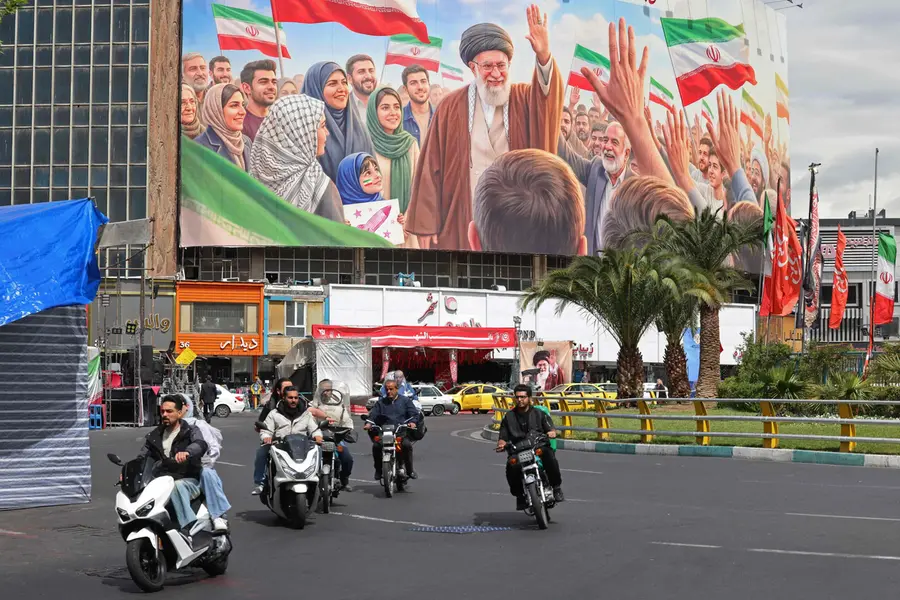 Motorists ride past a giant billboard of slain Iranian supreme leader Ayatollah Ali Khamenei at the Valiasr Square in Tehran