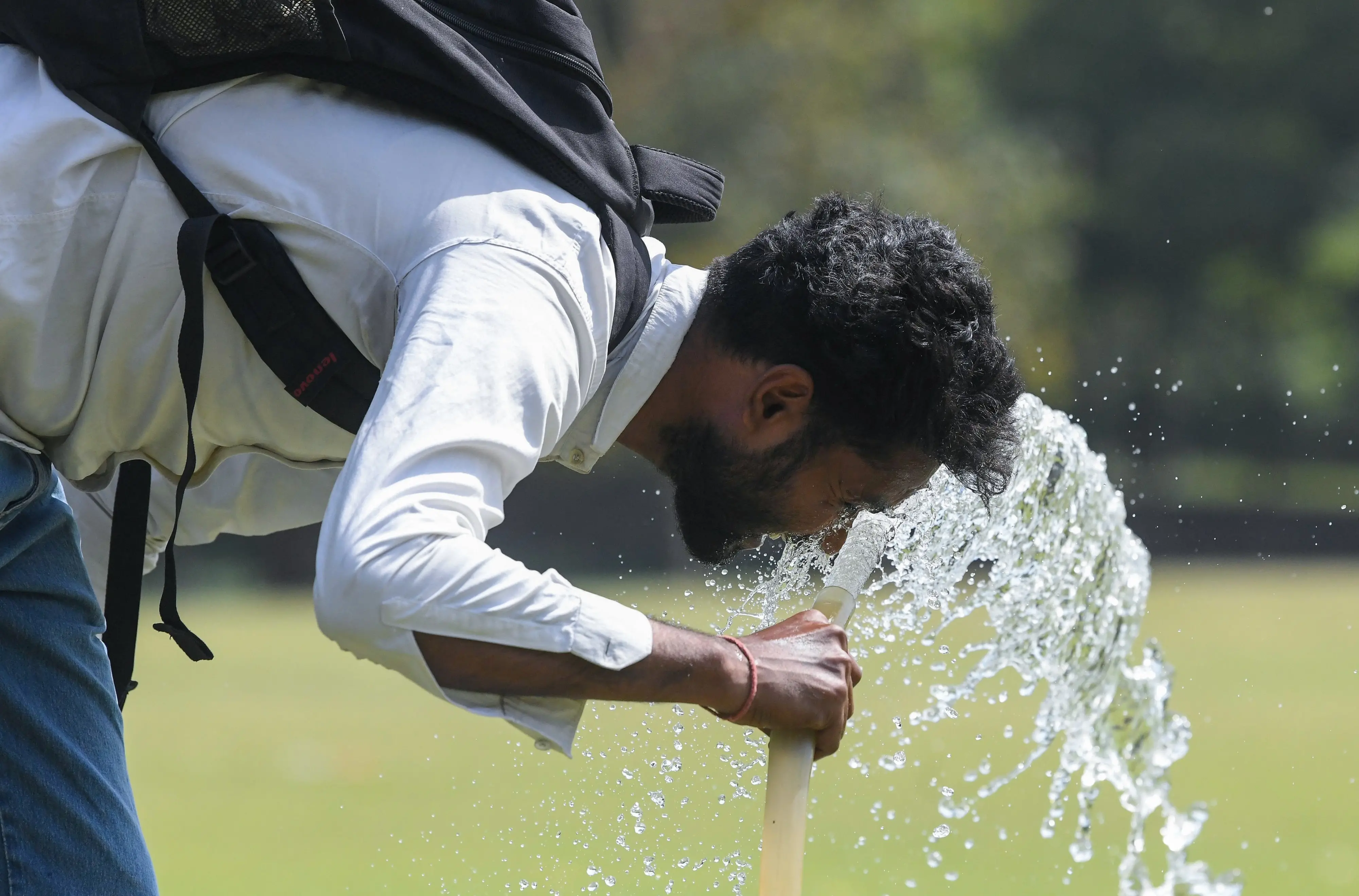 A man washes his face to beat the heat amid hot sunny weather in New Delhi (ANI Photo)