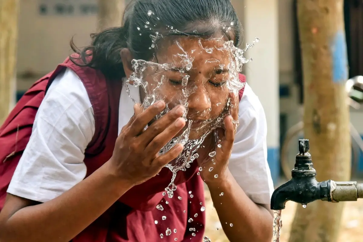 A school girl washing her face on a hot summer afternoon