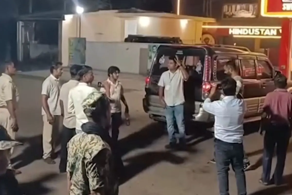 Locals gather around a roadside vehicle allegedly carrying reserve EVMs during Bengal poll phase 1, sparking opposition allegations of a security lapse.