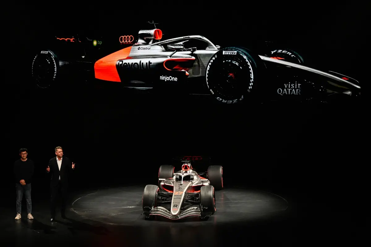 AUDI's F1 R26 model is displayed by CEO of German carmaker AUDI AG Gernot Dollner (R) during the Volkswagen Group Media Night event ahead of the Beijing Auto Show in Beijing.| Photo: AFP