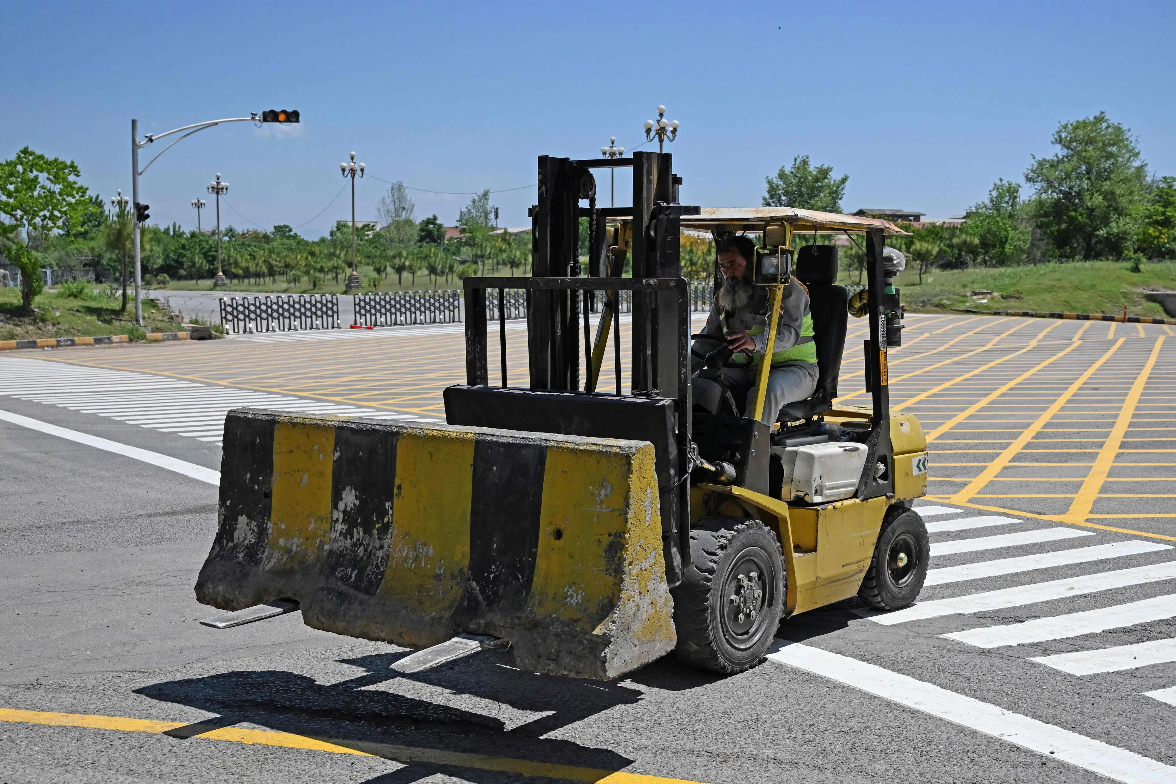 Traffic police removes barricades after authorities lifted the heightened security and restrictions imposed in the area ahead of anticipated US-Iran peace talks | Photo: AFP